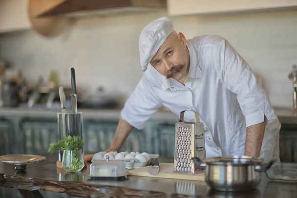 french chef in the kitchen preparing food, cooking, haute cuisine, man with mustache - Φωτογραφία, εικόνα