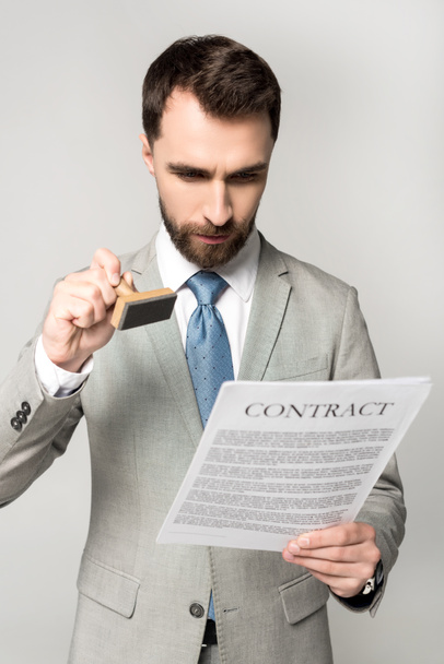 serious lawyer putting stamp on contract isolated on grey - Photo, Image