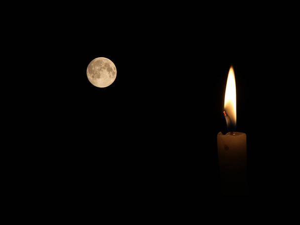 Una vela encendida brillantemente en el fondo negro - Foto, Imagen