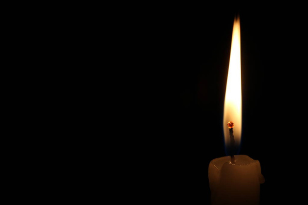 One light candle burning brightly in the black background - Photo, Image