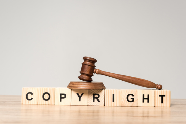 gavel on wooden cubes with word copyright on desk isolated on grey - Photo, Image
