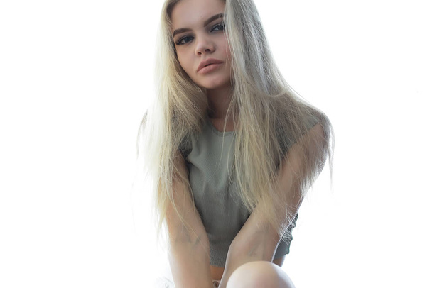 young adult blonde long hair at home, stylish model posing in the studio - Fotó, kép