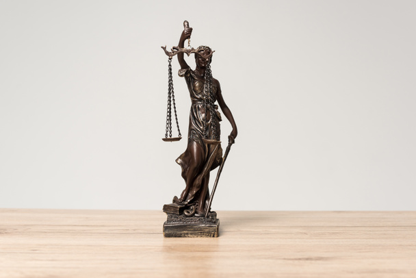 themis statue on wooden desk isolated on grey - Photo, Image