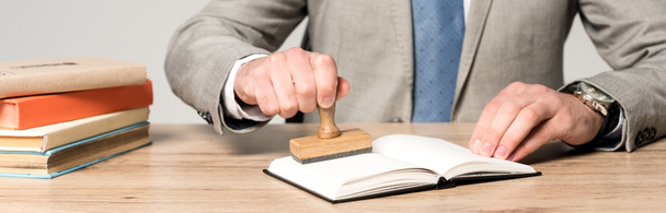 обрезанный вид юриста, помещающего штамп в блокнот изолированный на сером, панорамный снимок
 - Фото, изображение