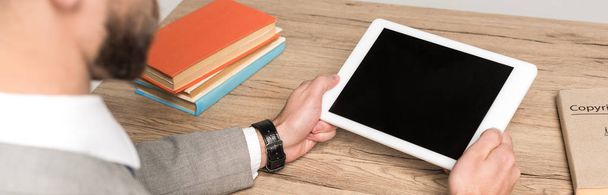 partial view of businessman holding digital tablet with blank screen isolated in grey, panoramic shot - Photo, Image