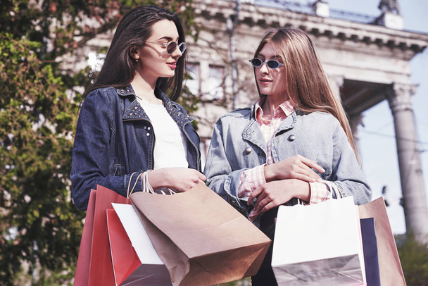 Beautiful girls with shopping bags walking at the mall. - Фото, зображення