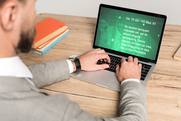 vista recortada del hombre de negocios utilizando el ordenador portátil con el sitio web médico en la pantalla aislada en gris
 - Foto, Imagen
