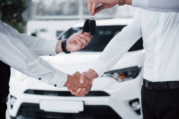 Close up of sales manager in black suit selling the car to the customer. - Foto, imagen
