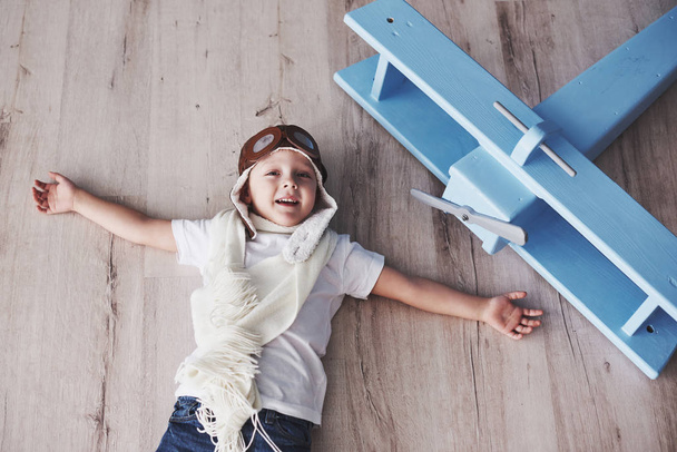 Child pretend to be pilot. Kid having fun at home. Vintage pilot and travel concept. Top view portrait. - Fotó, kép