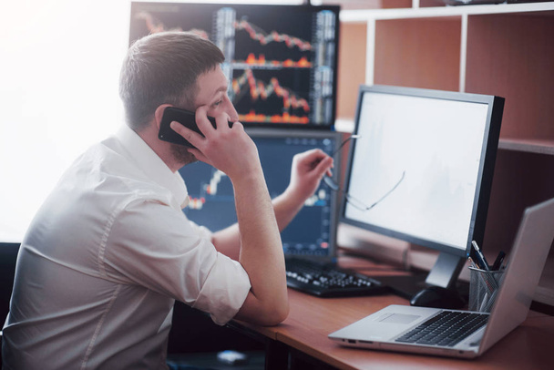Stockbroker in shirt is working in a monitoring room with display screens. Stock Exchange Trading Forex Finance Graphic Concept. Businessmen trading stocks online. - Foto, afbeelding