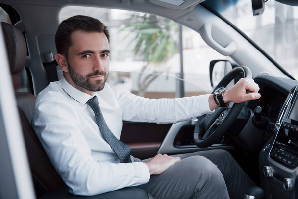 Confident young businessman sitting at the wheel of his new car. - Foto, Imagem