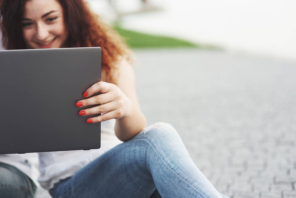 Вид жінки в парку з ноутбуком, руки на ноутбуці
 - Фото, зображення