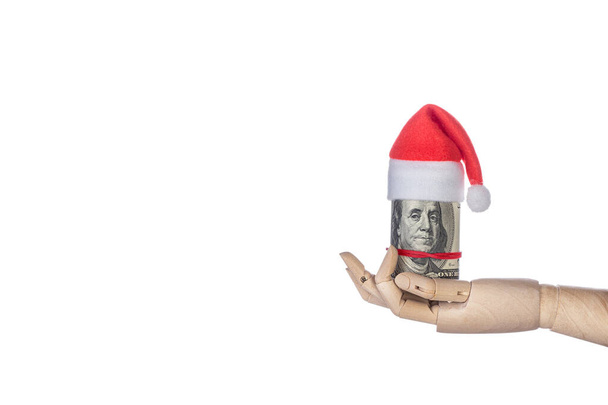 Wooden hand holding Christmas money gift with Santa Claus hat on white background - Photo, Image