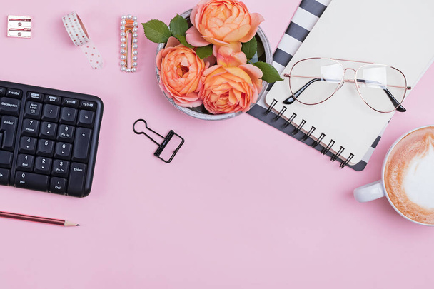Styled womans workplace with stationary, keybord, notepads and beautiful roses - 写真・画像