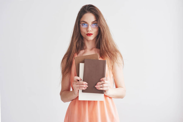 Photo of young woman in the glasses and red lips holding the books. - Valokuva, kuva