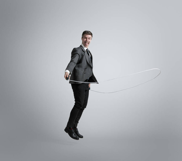 Caucasian man in office clothes training isolated on grey studio background - Foto, imagen