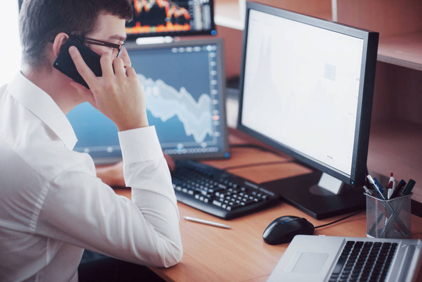Stockbroker in shirt is working in a monitoring room with display screens. Stock Exchange Trading Forex Finance Graphic Concept. Businessmen trading stocks online. - 写真・画像
