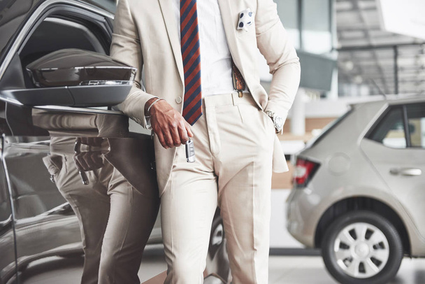 The young attractive black businessman buys a new car, dreams come true. - Zdjęcie, obraz