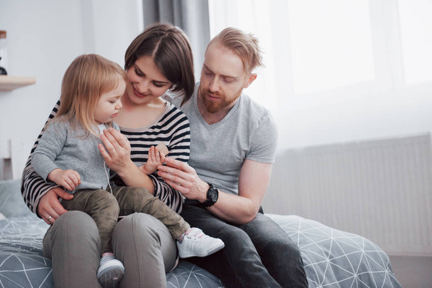 happy family mother, father and child daughter laughs in bed. - Foto, Bild