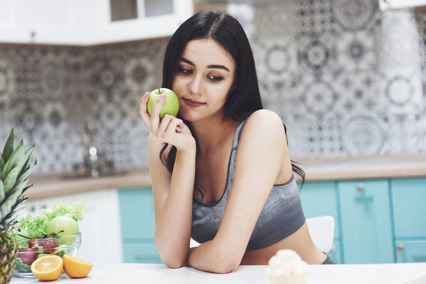 Beautiful woman with healthy food fruit in the kitchen. - Фото, зображення