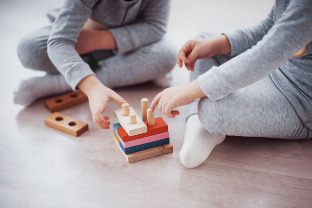 Children play with a toy designer on the floor of the children's room. Two kids playing with colorful blocks. Kindergarten educational games. - Valokuva, kuva