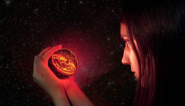 A fortune teller looks into a magic ball. Divination and fortune-telling, magical, spiritistic and witchcraft sessions for good luck and luck in life. Gypsy with the ball of fate and the galaxy. - Photo, Image