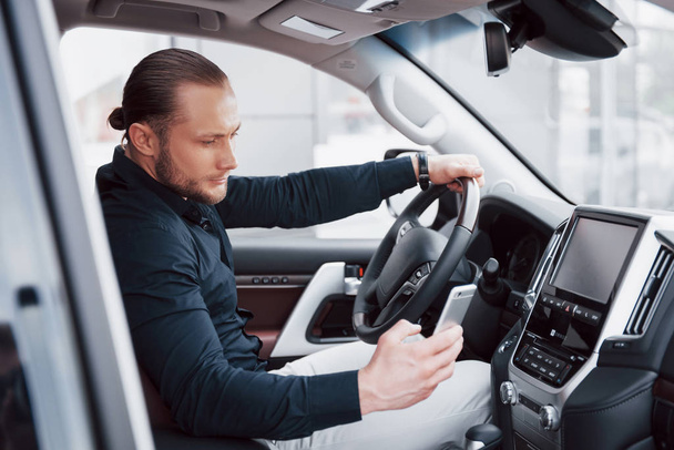 Confident young businessman sitting at the wheel of his new car. - Fotoğraf, Görsel