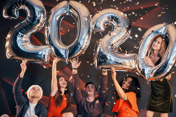 A group of fun young beautiful multinational people throwing confetti at a party. Happy New Year - Fotoğraf, Görsel