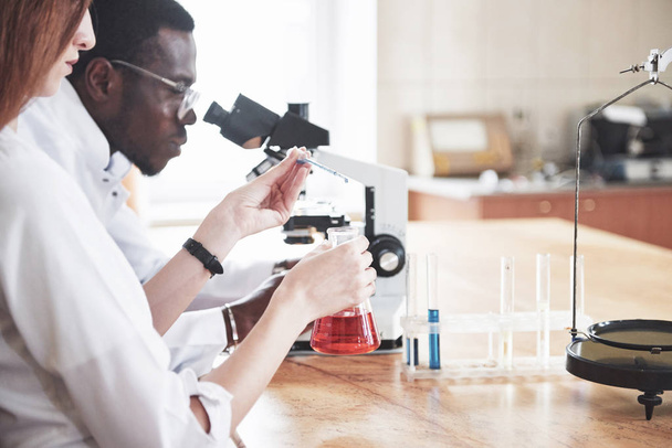 Scientists work closely with the microscope in the laboratory by conducting experiments and analyzes - Fotoğraf, Görsel
