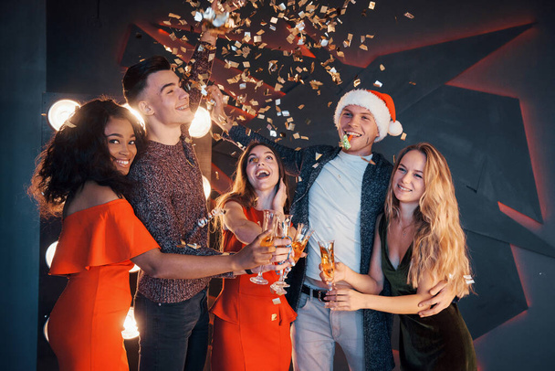 Grupa przyjaciół pozowanie i zabawy z bałwanami i szampanem. Obchody Nowego Roku - Zdjęcie, obraz