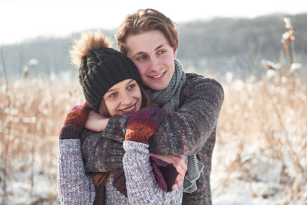 Couple has fun and laughs. kiss. Young hipster couple hugging each other in winter park. Winter love story, a beautiful stylish young couple. Winter fashion concept with boyfriend and girlfriend. - Fotografie, Obrázek