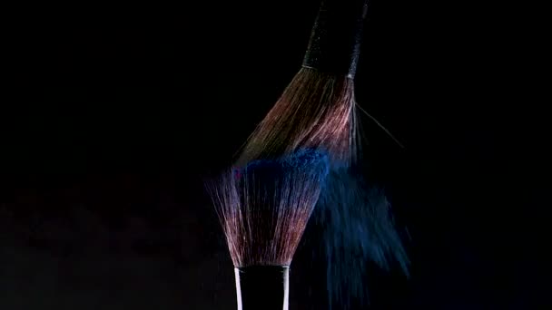 Two Soft cosmetic brushes release a cloud of colored smoke from bright eyeshadow and powder, - Materiaali, video