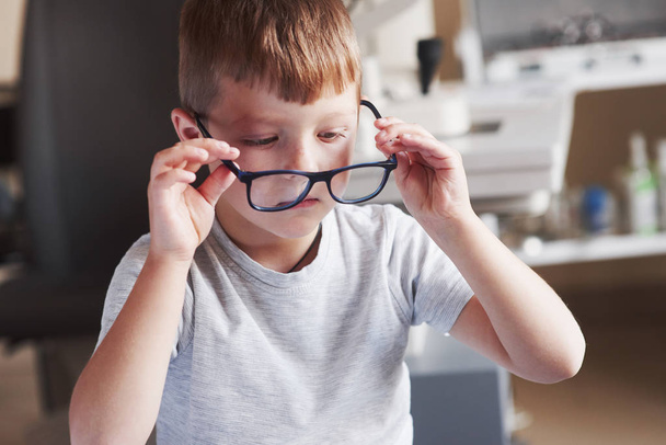 Kind probiert neue Brille im Schrank des Arztes an. - Foto, Bild