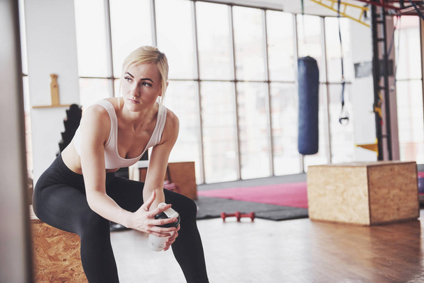 Photo of attractive fitness woman in gym holding bottle of water. - 写真・画像