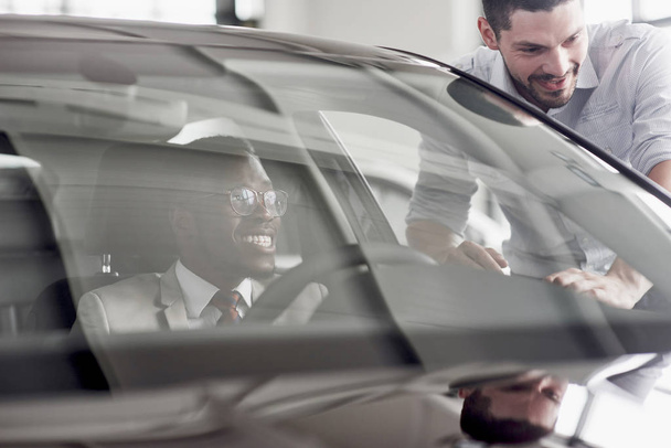 An African man who buys a new car checks a car talking to a professional vendor - Φωτογραφία, εικόνα
