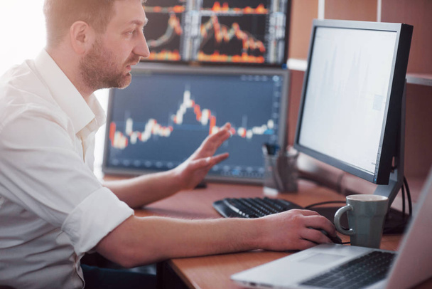 Stockbroker in shirt is working in a monitoring room with display screens. Stock Exchange Trading Forex Finance Graphic Concept. Businessmen trading stocks online. - 写真・画像