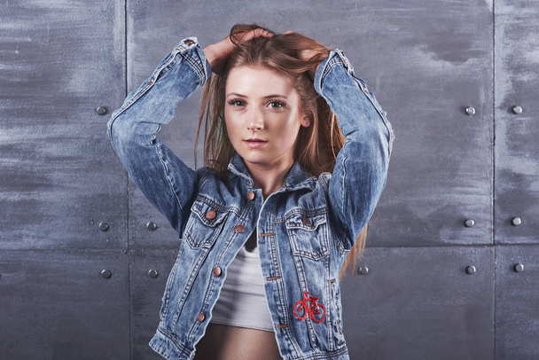 Fashion, clothing, people concept. Attractive sexy young woman with jeans jacket. Girl is posing in the studio. - Foto, Bild