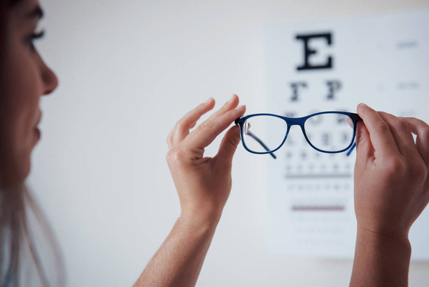 Close up. Photo from behind. Woman looking through the glasses eye chart. - Foto, imagen