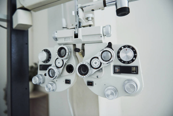 Phoropter standing in the office. Ophthalmologist devices in the beautiful white room. - Foto, imagen