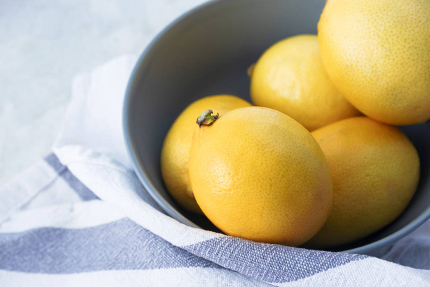 Primo piano limone giallo in ciotola e asciugamano sul tavolo di marmo. Frequenza grezza
 - Foto, immagini