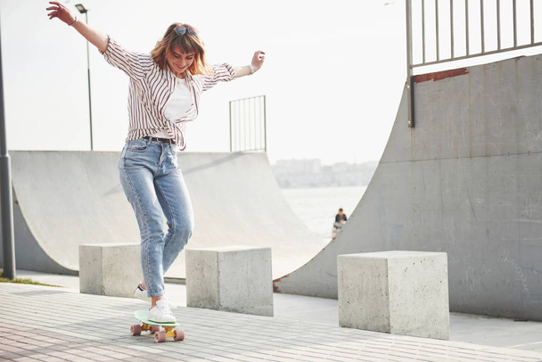 A young sports woman who rides in a park on a skateboard - Photo, Image