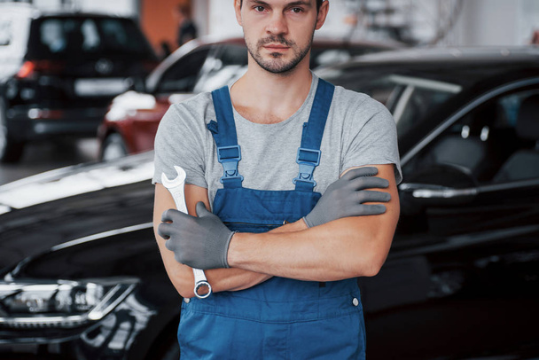 Hands of car mechanic with wrench in garage. - Valokuva, kuva