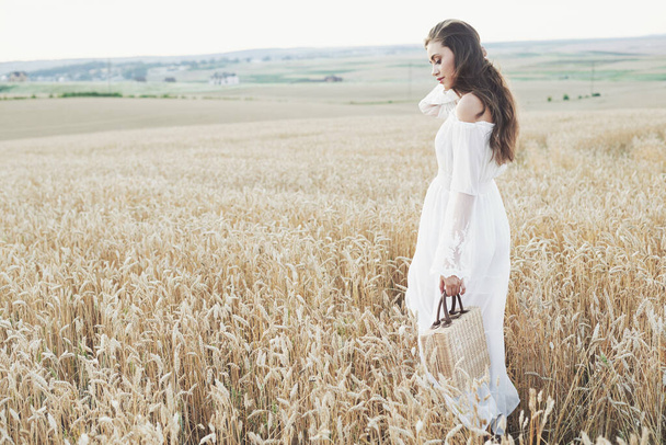 Beautiful girl in a field of wheat in a white dress, a perfect picture in the style lifestyle. - Fotó, kép