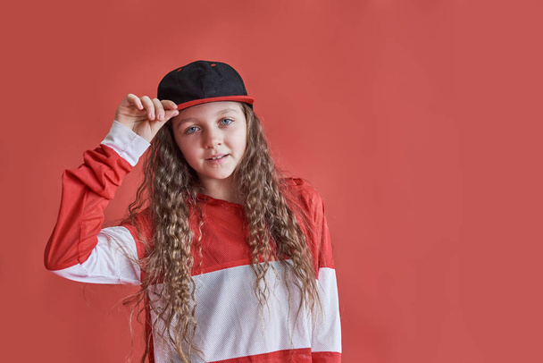 Young urban woman dancing on red background, modern slim hip-hop style teenage girl. - Fotó, kép