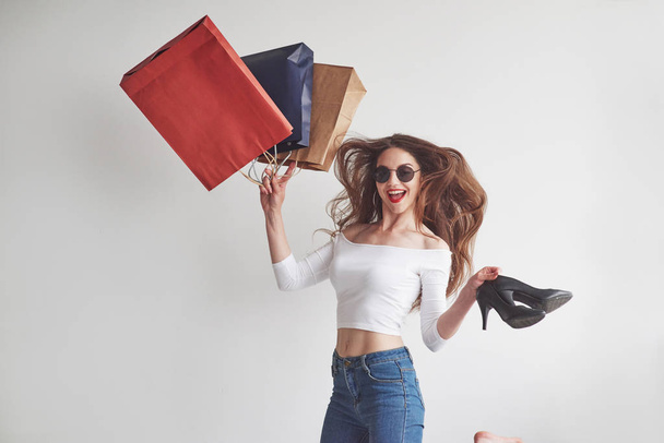 Finally upgraded my locker stuff. Just from the shopping. Stylish young woman holding the packages with clothes and heels. - Foto, imagen