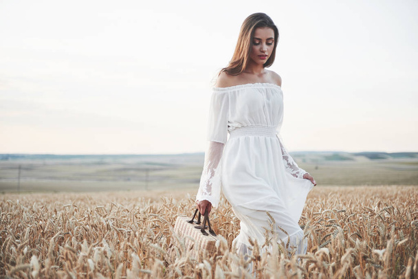 Happy young girl in a wheat field under sunlight - Fotografie, Obrázek