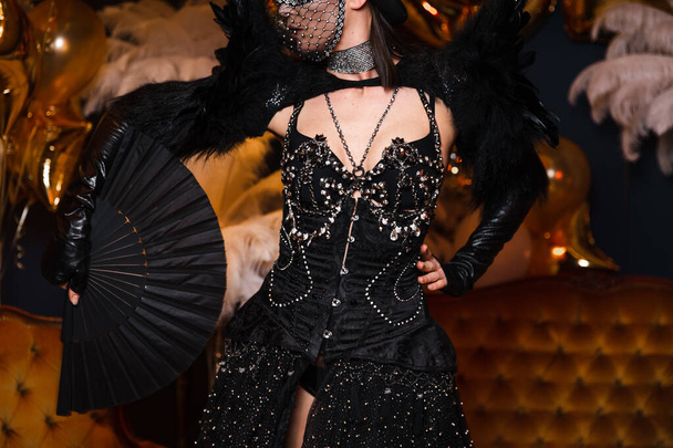 光沢のあるショーの女の子クレイジー黒革と羽の衣装とクリスタルで東ヨーロッパラトビアリガ企業イベント開催ファン - 写真・画像