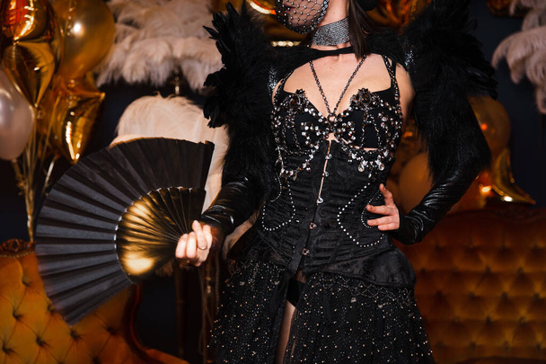 Filles spectacle brillant avec fou en cuir noir et des tenues de plumes avec des cristaux en Europe de l'Est Lettonie Riga événement d'entreprise tenant ventilateur
 - Photo, image