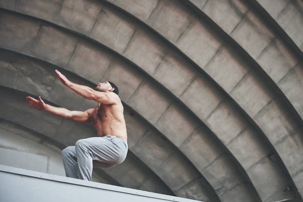 The man outdoors practices parkour, extreme acrobatics - Valokuva, kuva