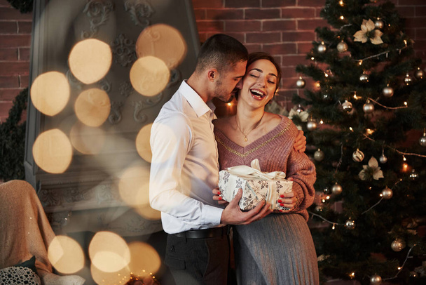 New year happiness. Christmas gift for the woman. Gentleman in classic suit gives his wife the present. - Zdjęcie, obraz